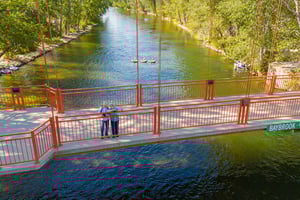 Senior couple standing on a red bridge over the river
