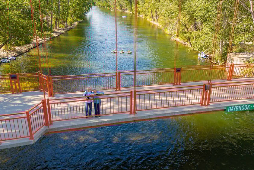 Senior couple standing on a red bridge over the river