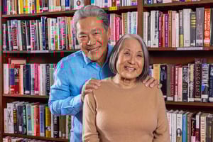 Senior man with his hands on the shoulders of a senior woman in a library