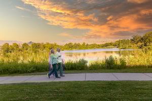 Senior couple walking by the river at sunset