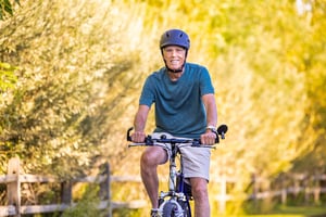 Senior man wearing a helmet and riding a bike