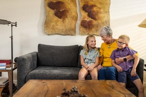 Senior woman sitting on a couch with her young granddaughter and grandson