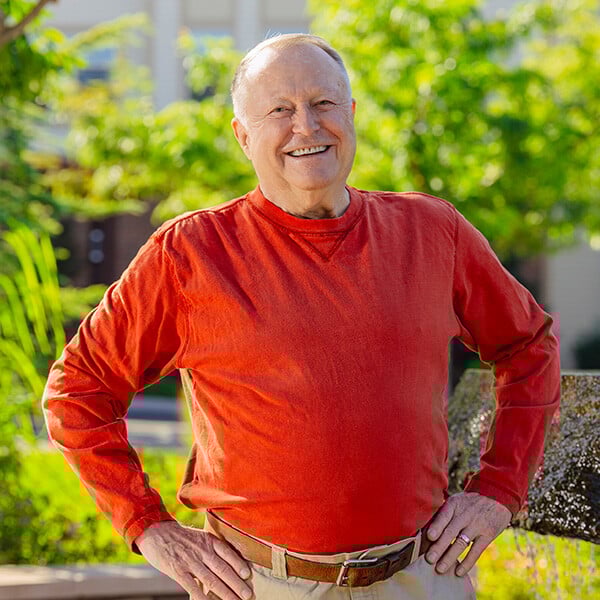 Smiling senior man in red sweater standing outside