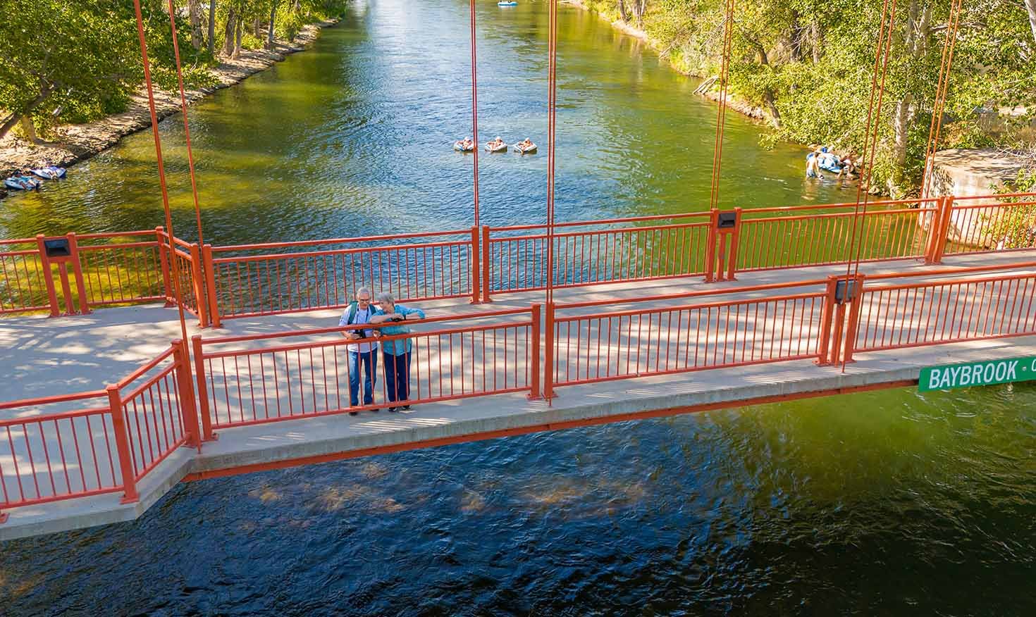 Senior couple standing on a red bridge over the river
