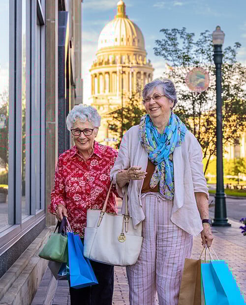 Two senior women shopping in Boise, Idaho, with the state capitol in the background