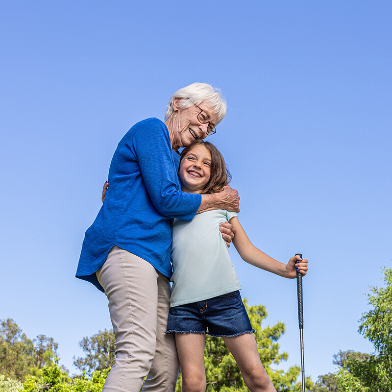 Senior woman hugging a young girl