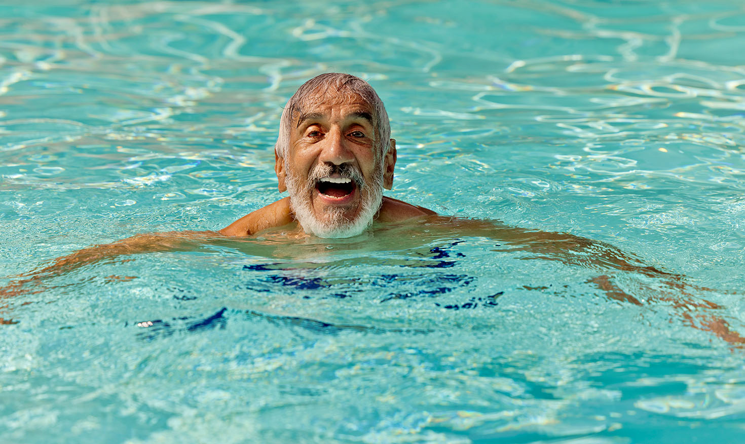 Senior man swimming in the pool at Valle Verde