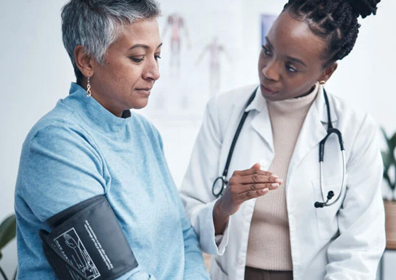 Female medical professional taking the blood pressure of a senior woman
