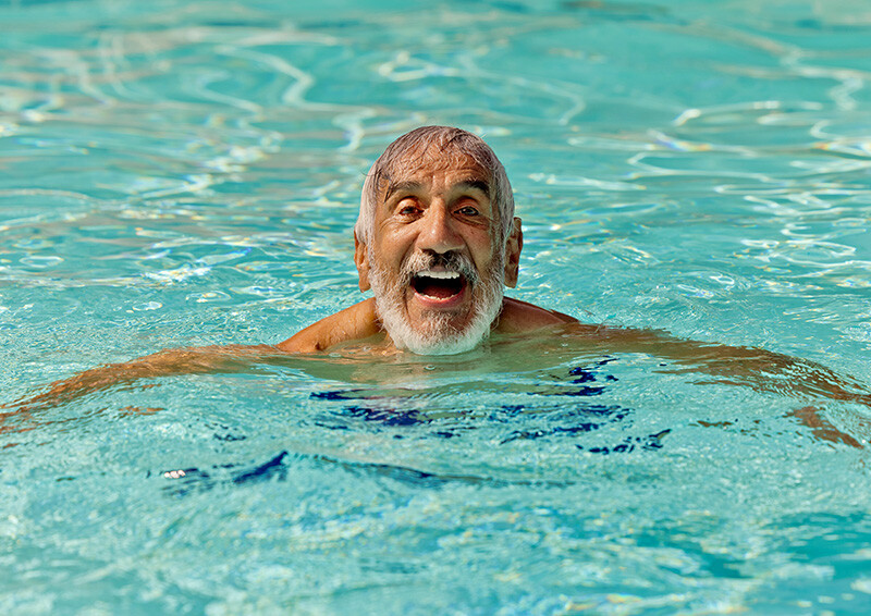 Senior man swimming in the pool at Valle Verde