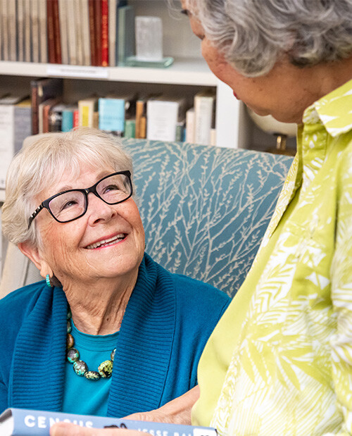 Two senior women inside the library