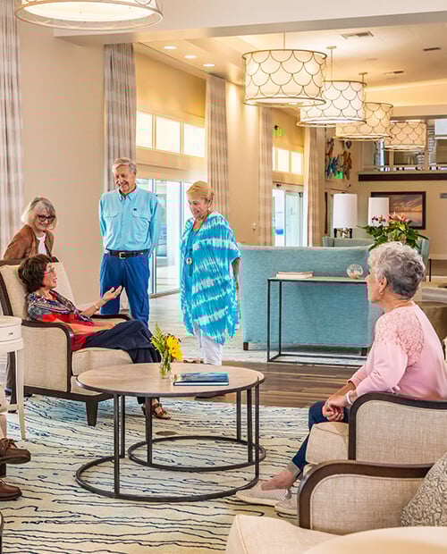 Group of seniors chatting in a common seating area of White Sands