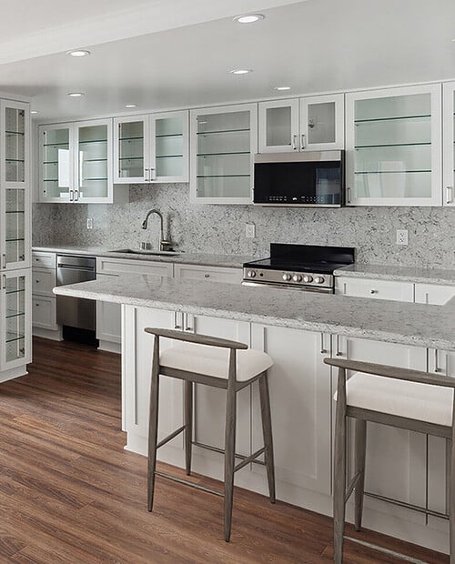 Kitchen of an apartment at White Sands La Jolla with white cabinets and granite countertops