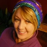 Cindy Proctor smiling while wearing a colorful hat
