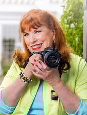 Senior woman holding a Nikon camera