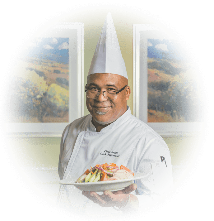 A chef at a HumanGood Life Plan Community holding up a dish