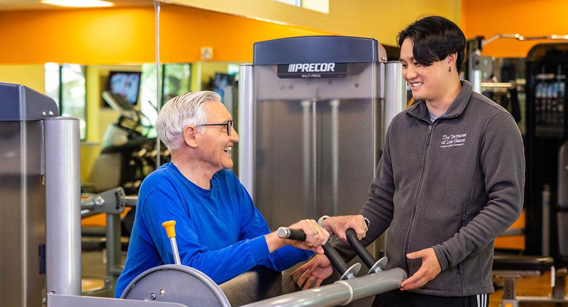 Senior man in a fitness center working with a personal trainer