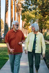 Senior couple walking down the sidewalk in Plymouth Village