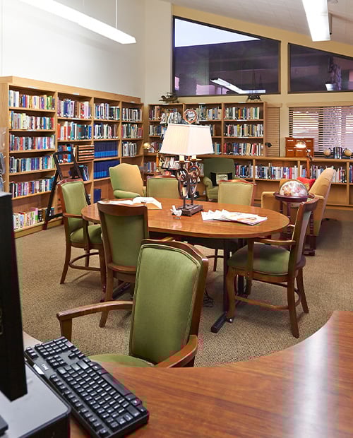 Bookshelves and seating areas in the library at Plymouth Village
