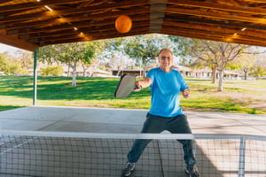Senior man playing pickleball at Plymouth Village