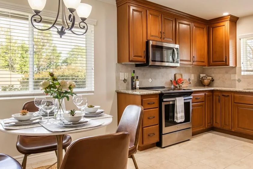 Kitchen with brown wood cabinets and small dining room in a Plymouth Village home