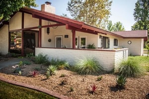 Exterior of a Plymouth Village home with a white brick fence around a patio