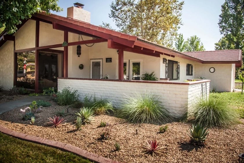 Exterior of a Plymouth Village home with a white brick fence around a patio