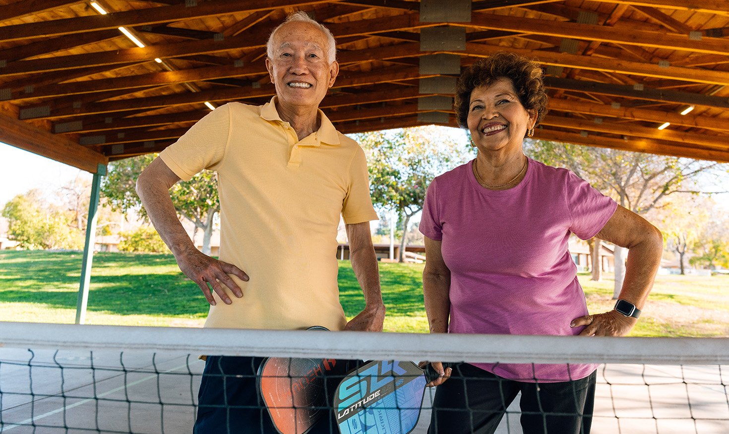 Senior man and woman standing on the pickleball court at Plymouth Village