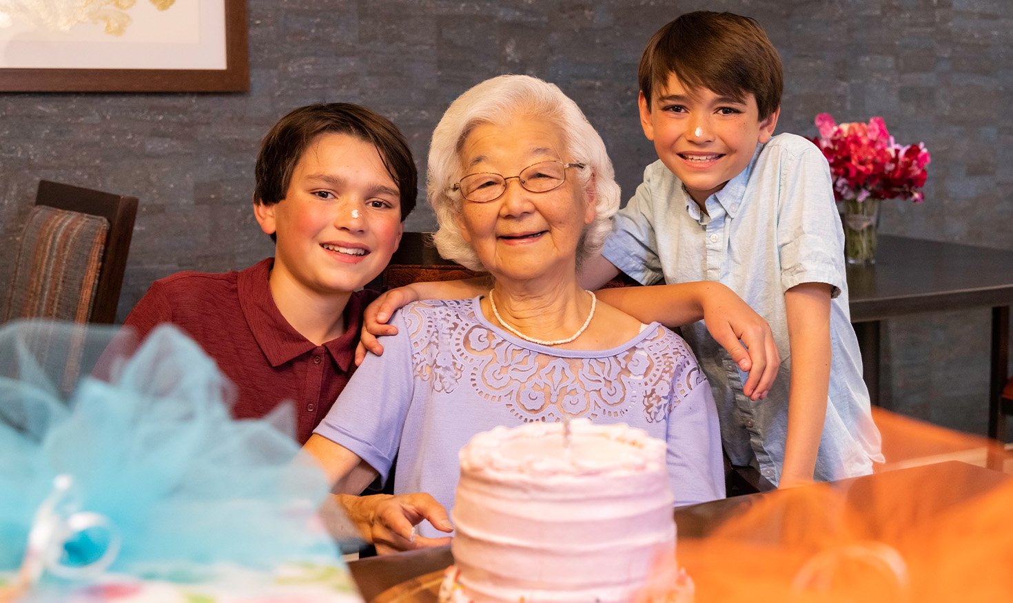 Senior woman and her grandchildren with a birthday cake