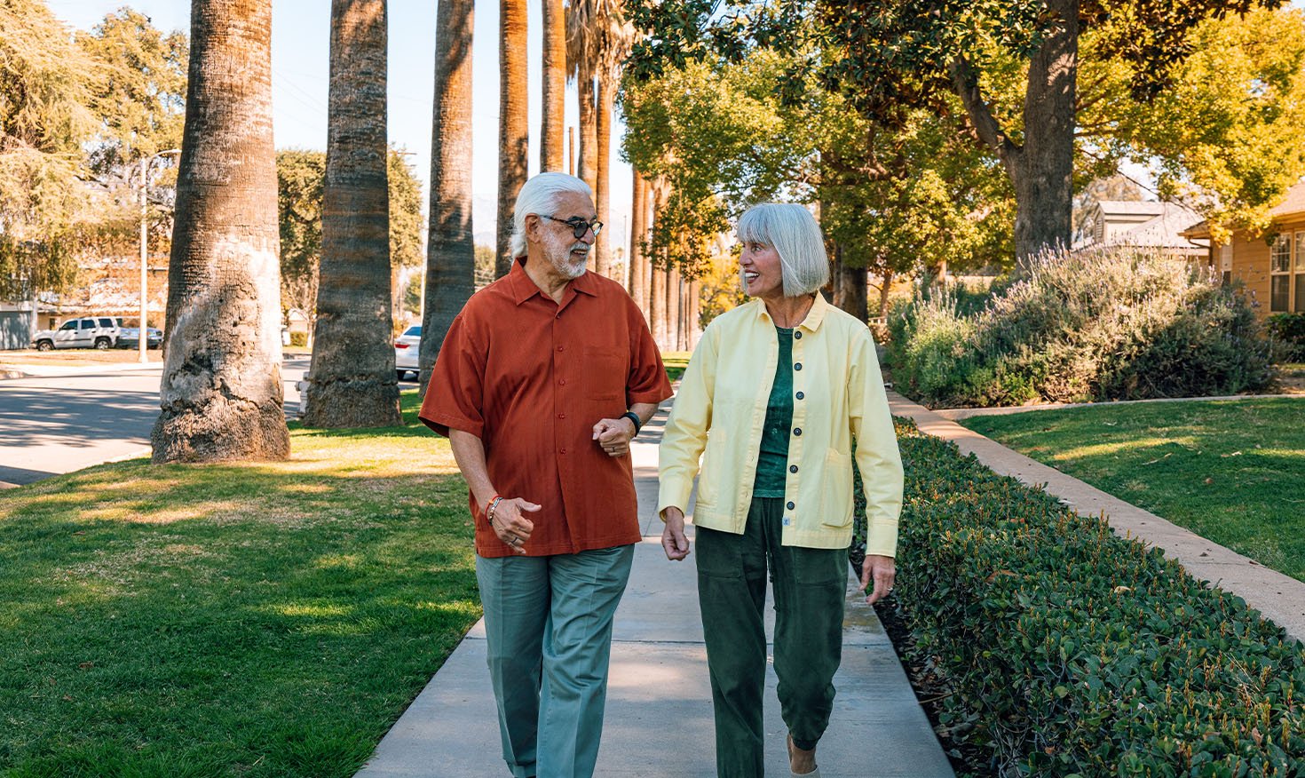 Senior couple walking down the sidewalk in Plymouth Village
