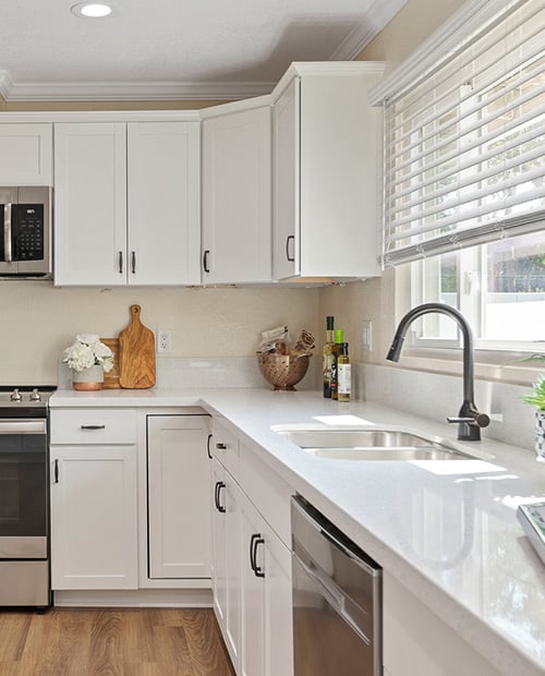 White cabinets and countertops in the kitchen of a Plymouth Village home