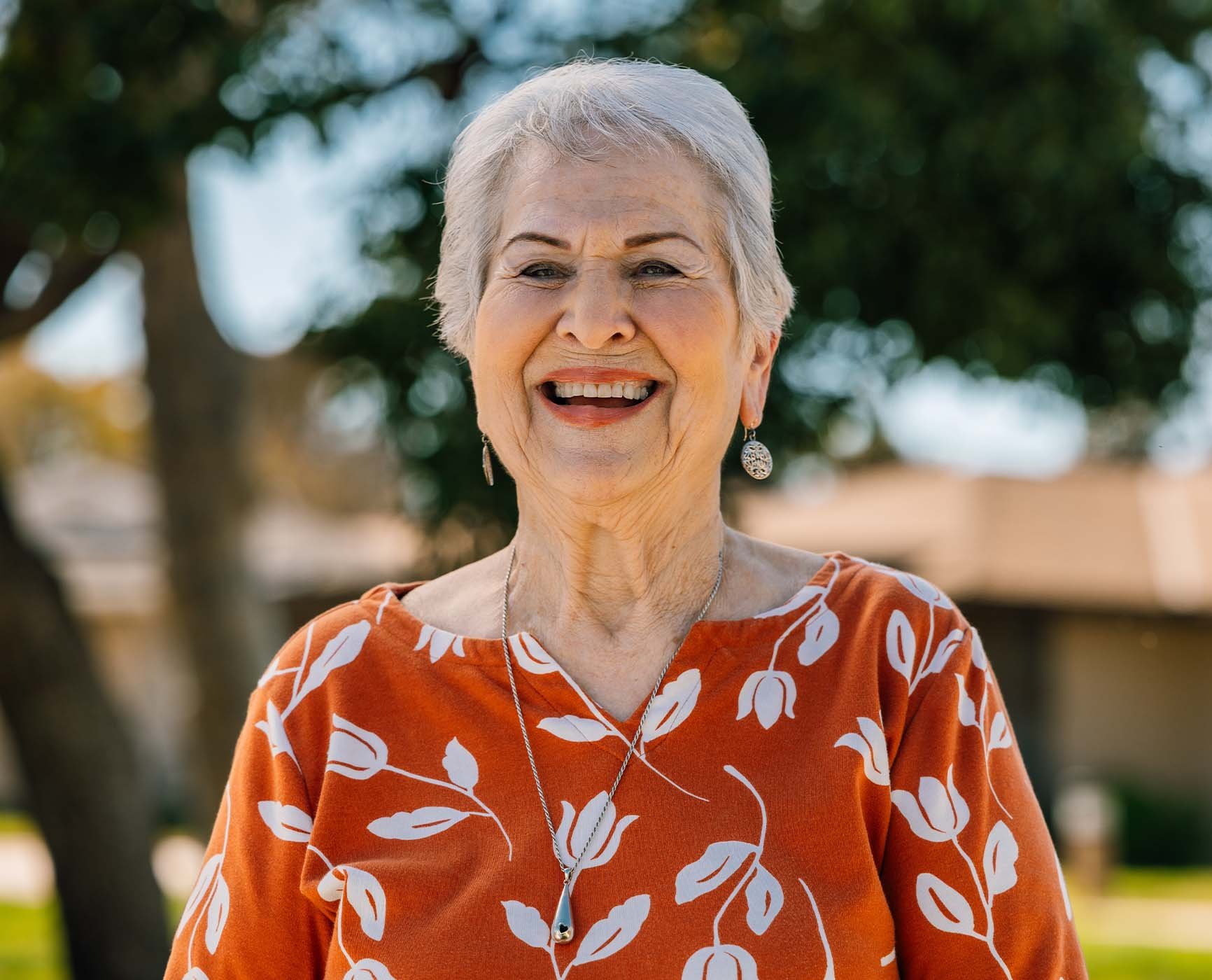 Smiling senior woman standing outside in the Plymouth Village Life Plan Community