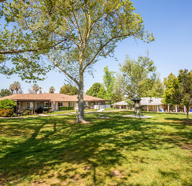 Exterior of single-level homes and green spaces at Plymouth Village, a HumanGood Life Plan Community in Redlands, California