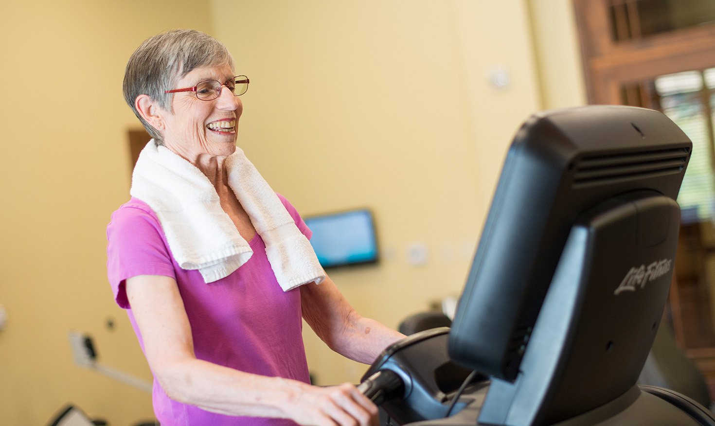 Senior using an exercise machine in the Spring Mill Pointe fitness center