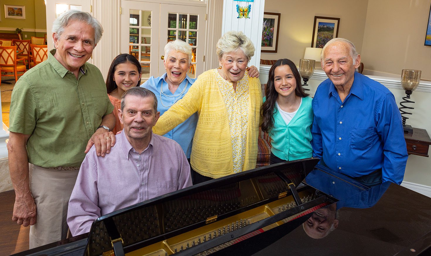 Smiling family gathered around a piano
