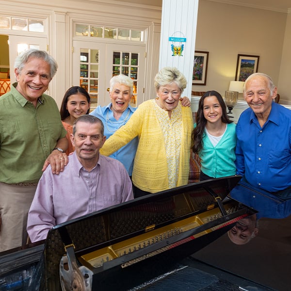 Smiling family gathered around a piano