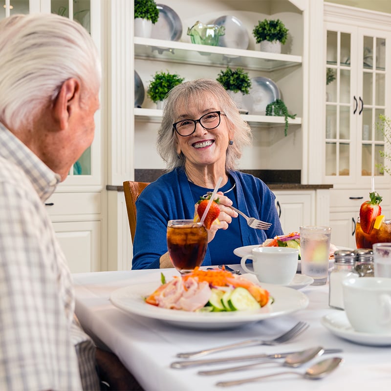 Senior man and senior woman enjoying lunch in the Spring Mill Pointe dining room