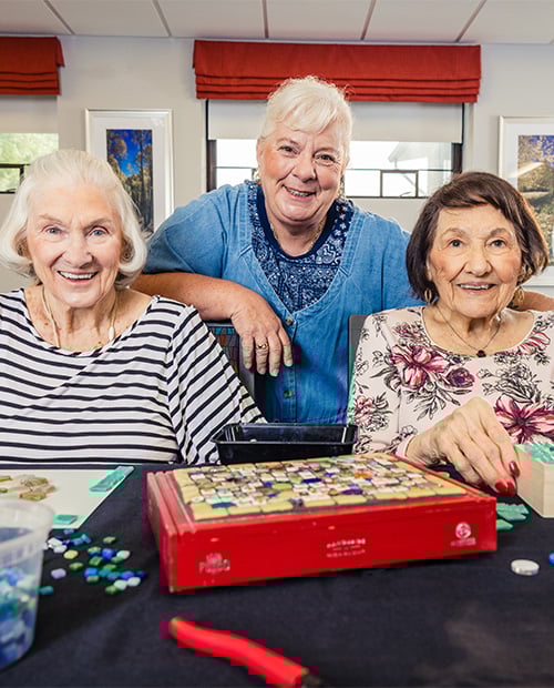 Three smiling senior women doing crafts
