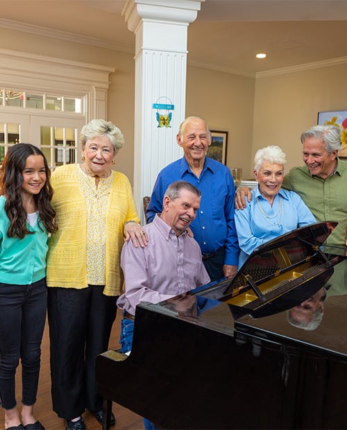 Smiling family gathered around a piano