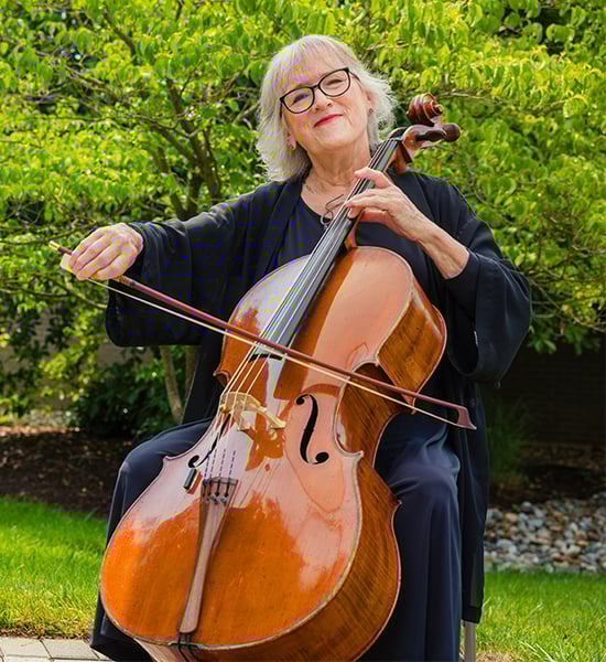 senior playing the cello outside