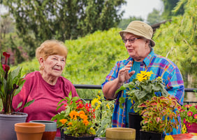 Two senior women gardening on the grounds of Spring Mill Pointe