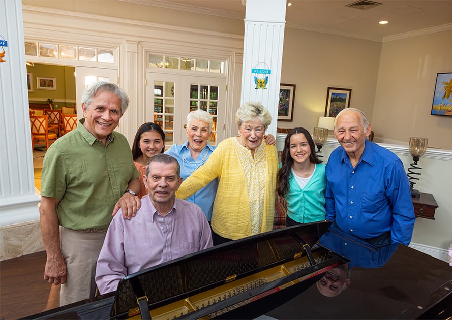 Smiling family gathered around a piano