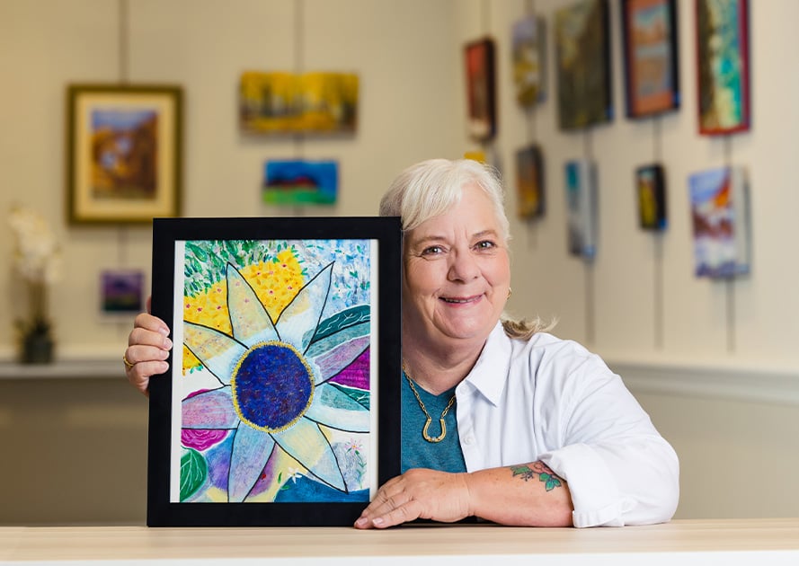 Senior woman holding up her artwork