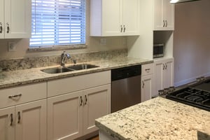 Kitchen with white cabinets and granite countertops in a Westminster Gardens home