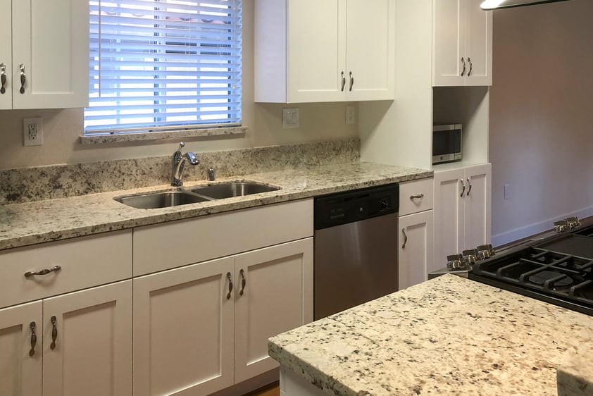 Kitchen with white cabinets and granite countertops in a Westminster Gardens home