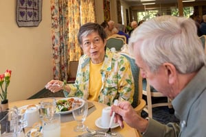 Senior man and woman enjoying a meal in the Westminster Gardens dining room