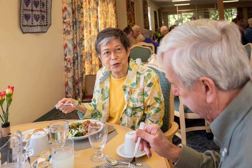 Senior man and woman enjoying a meal in the Westminster Gardens dining room
