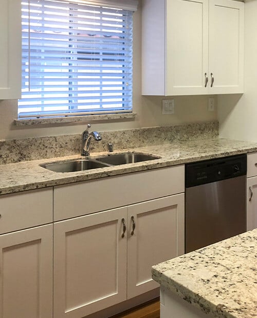 Kitchen with white cabinets and granite countertops in a Westminster Gardens home