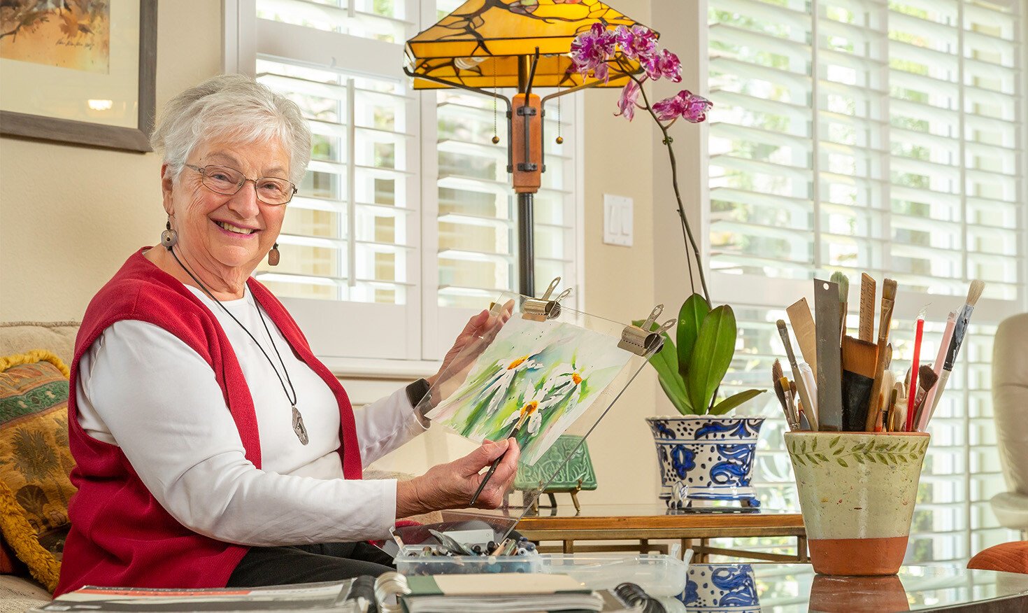 Senior woman holding up a watercolor painting