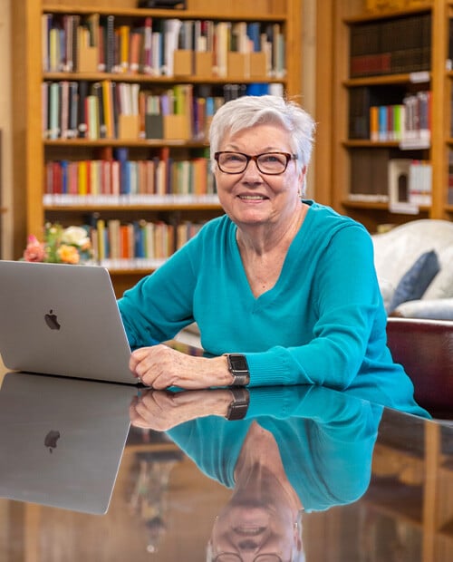 Senior woman sitting in front of her computer in the Westminster Gardens library