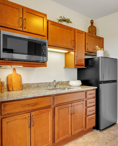 Kitchen with brown cabinets, a microwave, and refrigerator